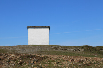 A square white building once used by the coast watch at Mynydd, Llyn Peninsula, Wales, UK.