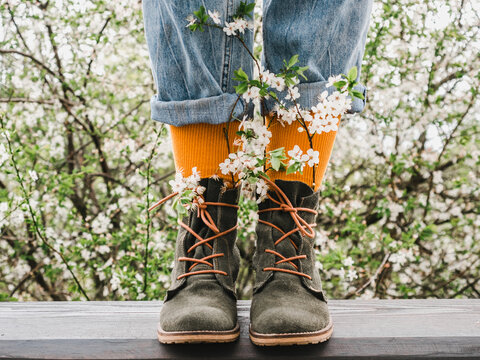 Trendy shoes and bright socks on the background of a flowering tree. Close-up. Men's and women's style. Beauty, elegance concept
