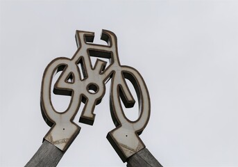 A closeup view of a stylised bicycle above a bike and walking track in Wales, UK.
