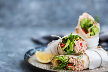 Fresh and healthy wrapped tortilla with crab salad, cucumber, avocado, pepper and green herbs