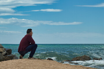 Fototapeta na wymiar lonely man on the beach shore looking the horizon