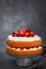 Victoria`s sponge cake, delicious homemade vanilla cake decorated with whipped cream and fresh strawberries