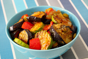 Ratatouille. Vegetable stew with eggplant, zucchini and bell peppers in a blue bowl - 433916166