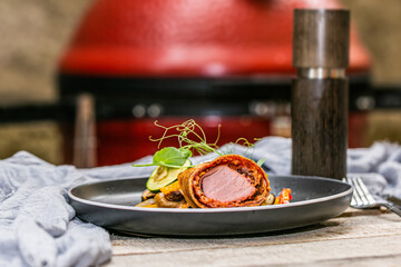 Grilled pork tenderloin in a roll with fresh vegetables and herbs.Close up