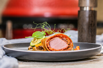 Grilled pork tenderloin in a roll with fresh vegetables and herbs.Close up