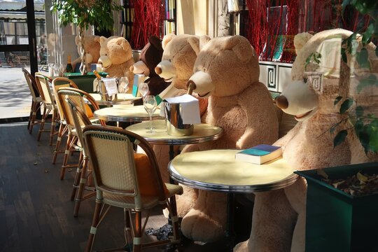 Plusieurs nounours (ours en peluche) assis à la terrasse d'un café / restaurant / brasserie à Paris, fermé pendant le confinement (lockdown) dû à la pandémie de covid 19 – avril 2021 (France)