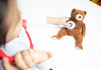Children role-play as doctor check teddy health
