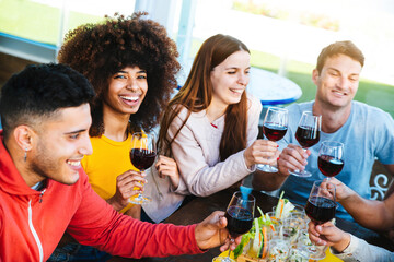 Diverse young people celebrating drinking wine at bar restaurant - Group of friends having fun eating brunch at dinner party - Friendship concept