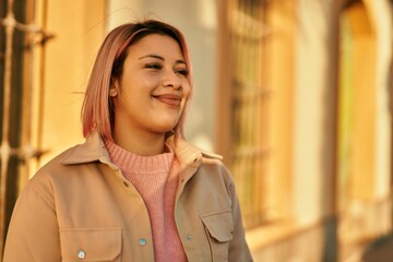 Fototapeta premium Young hispanic girl smiling happy standing at the city.