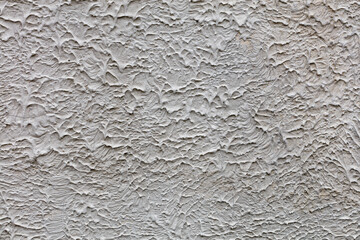 A gray textured wall covered with a frozen liquid concrete mixture, background and texture, close-up.