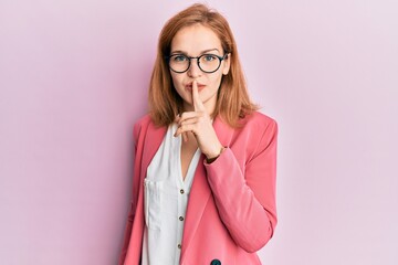 Young caucasian woman wearing business style and glasses asking to be quiet with finger on lips. silence and secret concept.