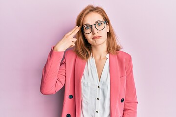 Young caucasian woman wearing business style and glasses shooting and killing oneself pointing hand and fingers to head like gun, suicide gesture.