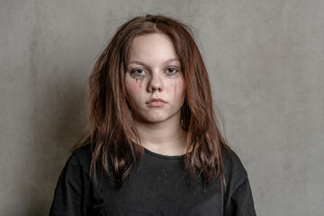 Fototapeta premium Portrait of a sad teenager on grey background