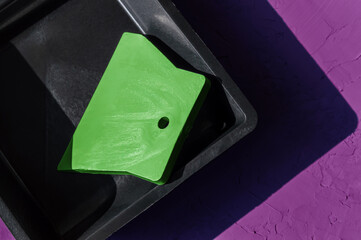 Paint tray with spatula on the colorful background.
