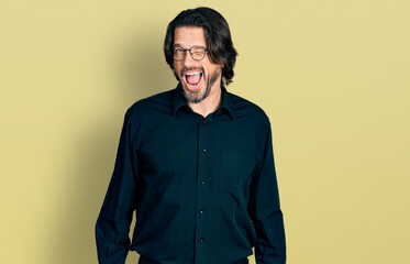 Middle age caucasian man wearing casual clothes and glasses winking looking at the camera with sexy expression, cheerful and happy face.