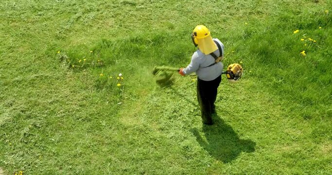 lawnmover man worker cutting dry grass with lawn mower.