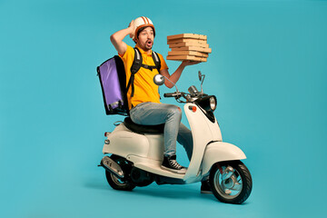 Young courier, pizza delivery man in uniform with thermo backpack on a moped isolated on blue background. Fast transport express home delivery. Online order.