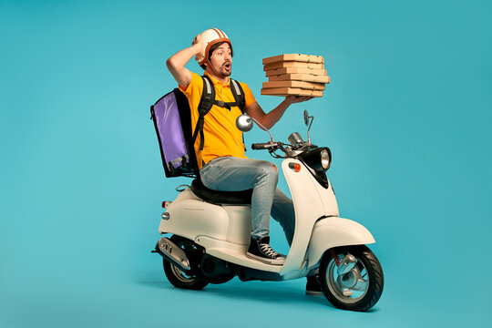 Young courier, pizza delivery man in uniform with thermo backpack on a moped isolated on blue background. Fast transport express home delivery. Online order.