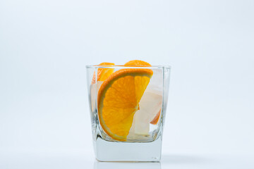Orange with ice in a glass. Refreshing drink with orange. Cold cocktail