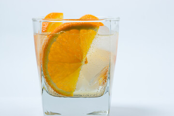 Orange with ice in a glass. Refreshing drink with orange. Cold cocktail