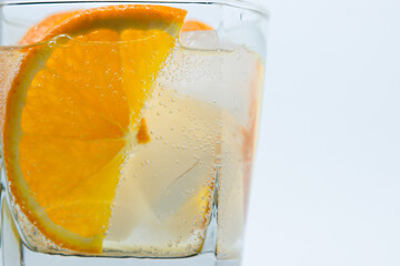 Orange with ice in a glass. Refreshing drink with orange. Cold cocktail