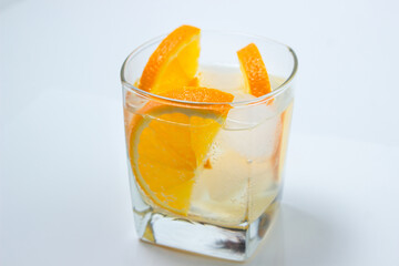 Orange with ice in a glass. Refreshing drink with orange. Cold cocktail