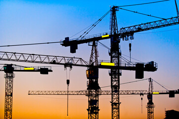 Mehrere Baukräne vor dem abendlichen Himmel