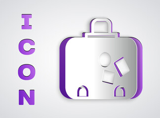 Paper cut Suitcase for travel icon isolated on grey background. Traveling baggage sign. Travel luggage icon. Paper art style. Vector