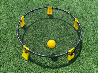 Spike ball game with yellow ball on the net