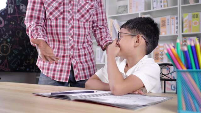 Kid sleeping during having a private class at home and teacher walking to complain a kid. A kid feels bored and lazy. Teacher getting angry with a kid. Private learning, Covid 19