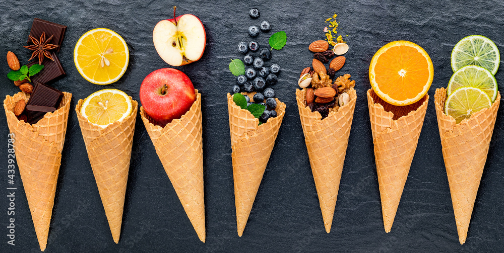 Poster various of ingredient for ice cream flavor in cones set up on dark stone background .