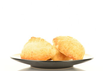 Several delicious pies with cherries on a ceramic saucer, close-up, isolated on white.