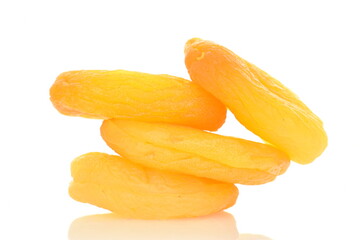 Several bright golden dried apricots, close-up, isolated on white.