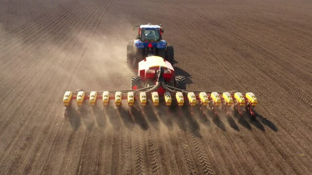 Tractor with seeder in the field, aerial view.
