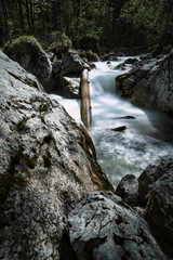 Timelapse of a floating mountain river in the forest with rocks inside
