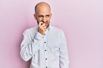 Young hispanic man wearing casual clothes looking stressed and nervous with hands on mouth biting nails. anxiety problem.