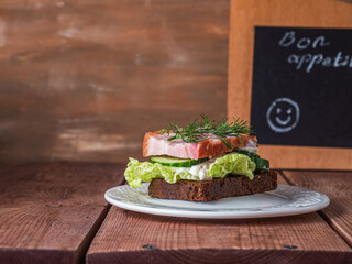 Rye bread sandwich with ham, cucumber, salad and curd cheese