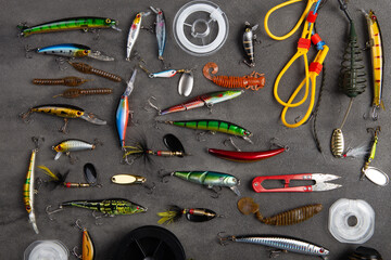 Fishing tackle - fishing spinning rod, hooks and lures on gray background. Active hobby recreation...