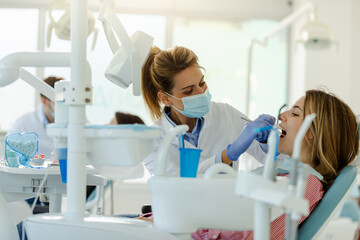 Young woman is being examined by dentist at dental clinic.