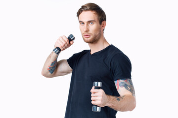 Fototapeta na wymiar sporty man in a black t-shirt with dumbbells in his hands on a white background