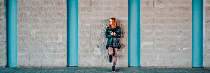 young woman or teenage girl standing outdoor on wall background