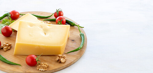 Gruyere cheddar cheese on wooden background. Local name gravyer peynir. Copy space