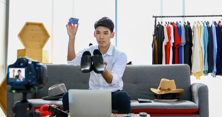 Asian man blogger broadcasting a video for selling product online .Shopping online and payment with...