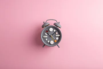 Foto op Canvas Creative healthcare and medicine concept - clock with drugs and pills.Right time for using medicines. Cold and flu season. Period of diseases © Sensay