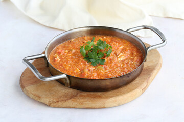 Tomato and peppered egg on wooden background. Local name menemen