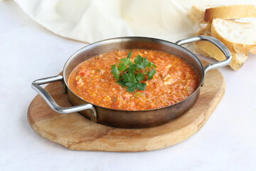 Tomato and peppered egg on wooden background. Local name menemen