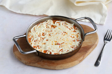 Tomato and peppered egg with melted cheese on wooden background