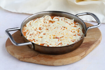Tomato and peppered egg with melted cheese on wooden background