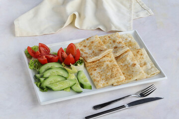 Traditional Turkish food gözleme with cheese and herb. Turkish pancake gozleme concept on the wooden background.