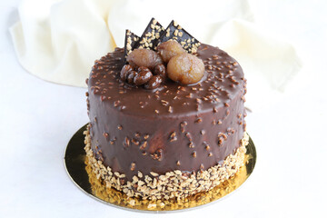 Chocolate and chestnut birthday cake on wooden background